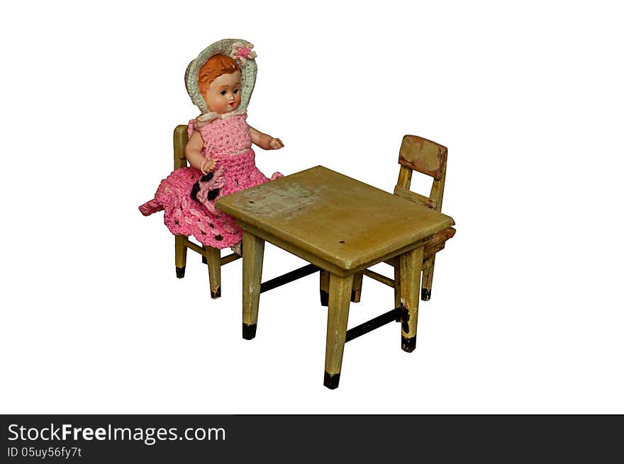 Vintage doll sitting at the table isolated on white background. Vintage doll sitting at the table isolated on white background