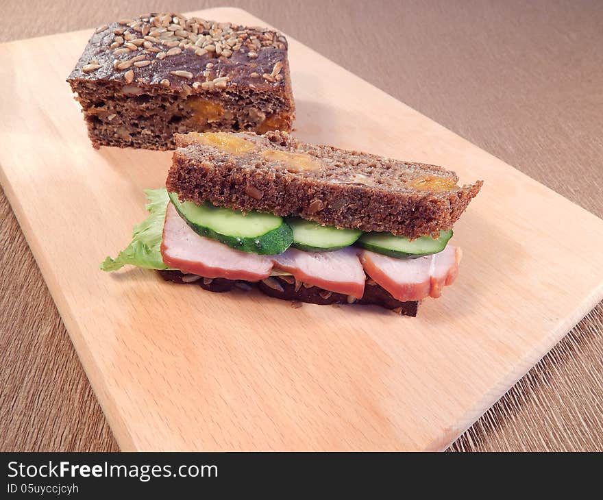 Sturgeon sandwich and salad leaves with cucumber, bread with dried apricots and beans