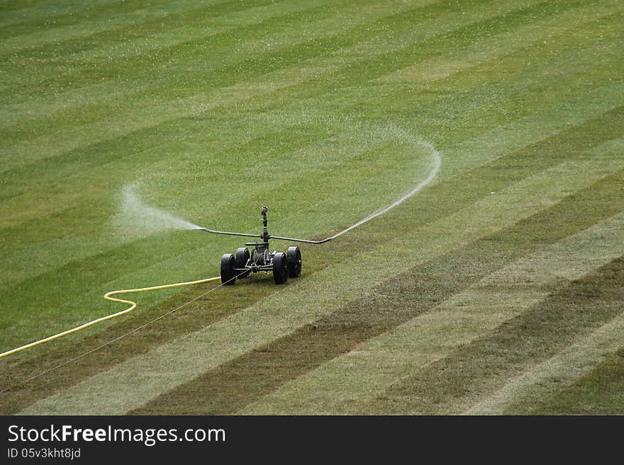 A Sprinkler Watering Newly Laid Grass Turf. A Sprinkler Watering Newly Laid Grass Turf.