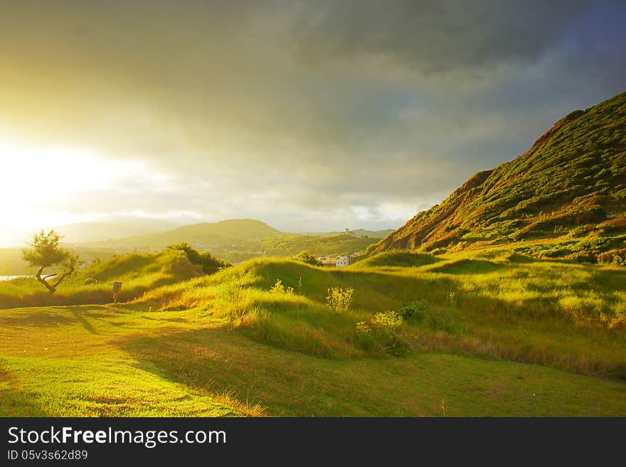 Sunset On Green Grass Hills