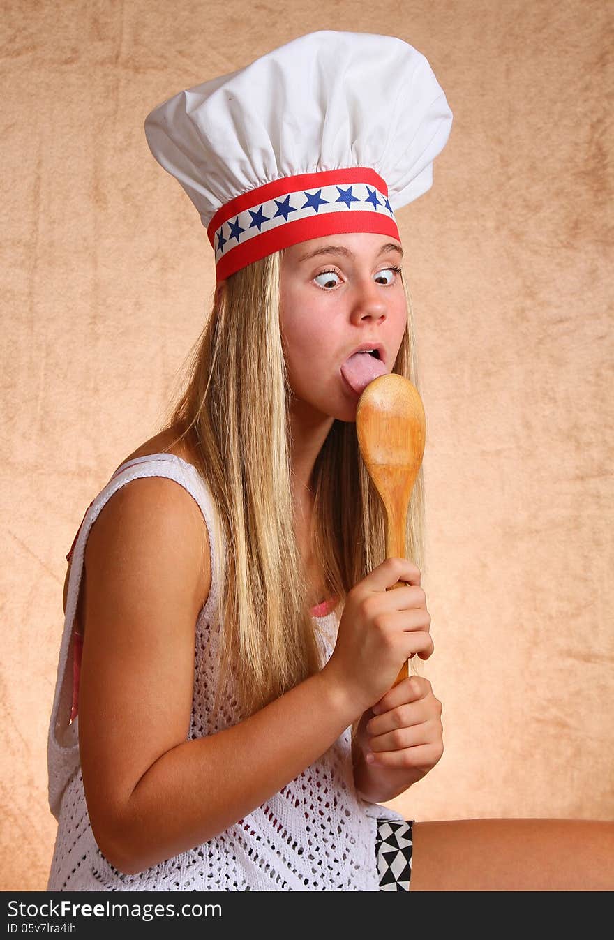 Teenage Female With Bakers Hat And Cooking Utensil. Teenage Female With Bakers Hat And Cooking Utensil