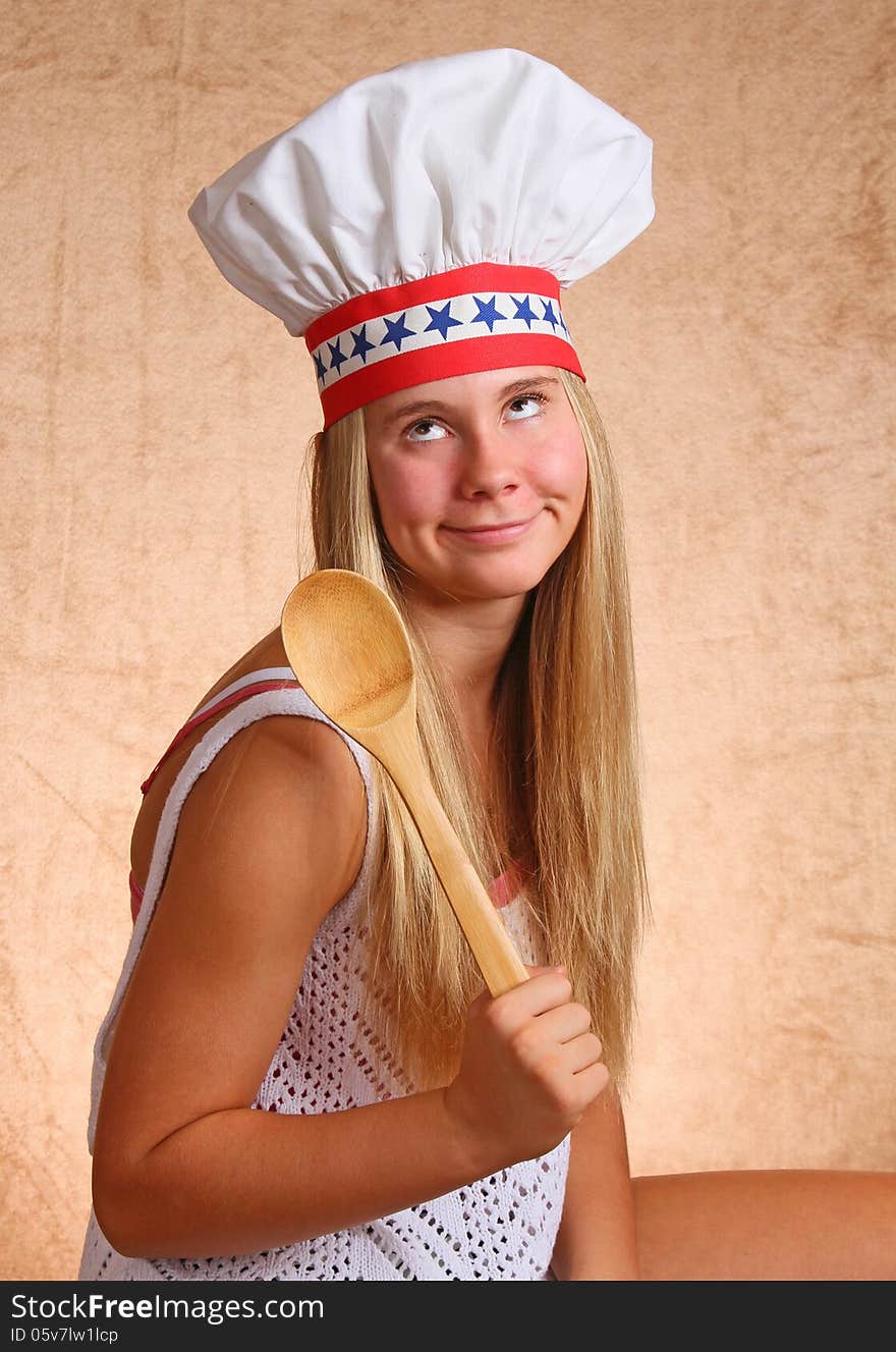 Teenage Female With Bakers Hat And Cooking Utensil. Teenage Female With Bakers Hat And Cooking Utensil