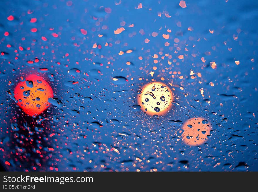 Drops of rain on window with bokeh lights abstract