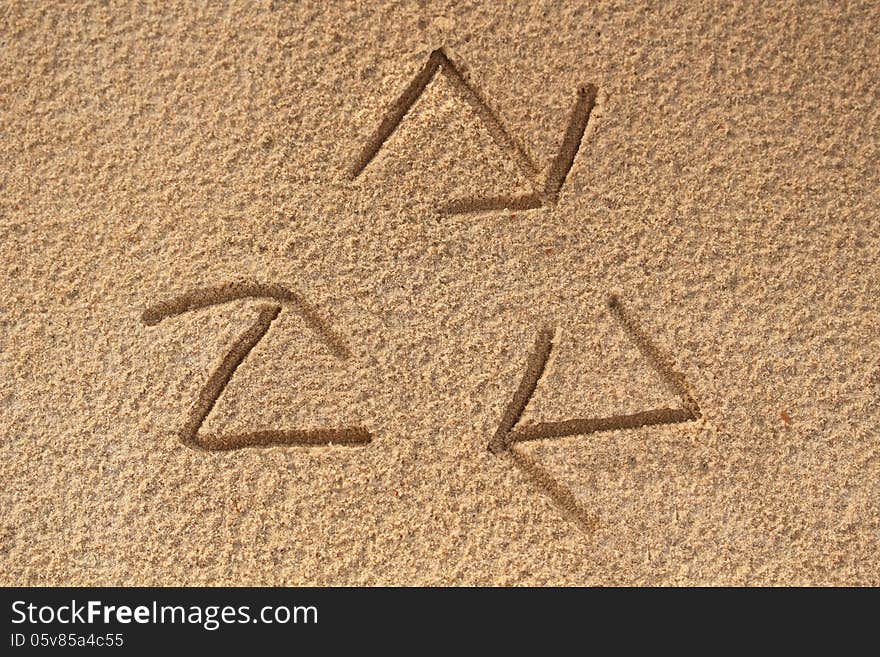 Recycle symbol written(drawn) in beach sand - concept photo. This photo shows a recycle sign with three arrows created in sea sand representing concept of saving nature, ecosystem and planet earth. Recycle symbol written(drawn) in beach sand - concept photo. This photo shows a recycle sign with three arrows created in sea sand representing concept of saving nature, ecosystem and planet earth