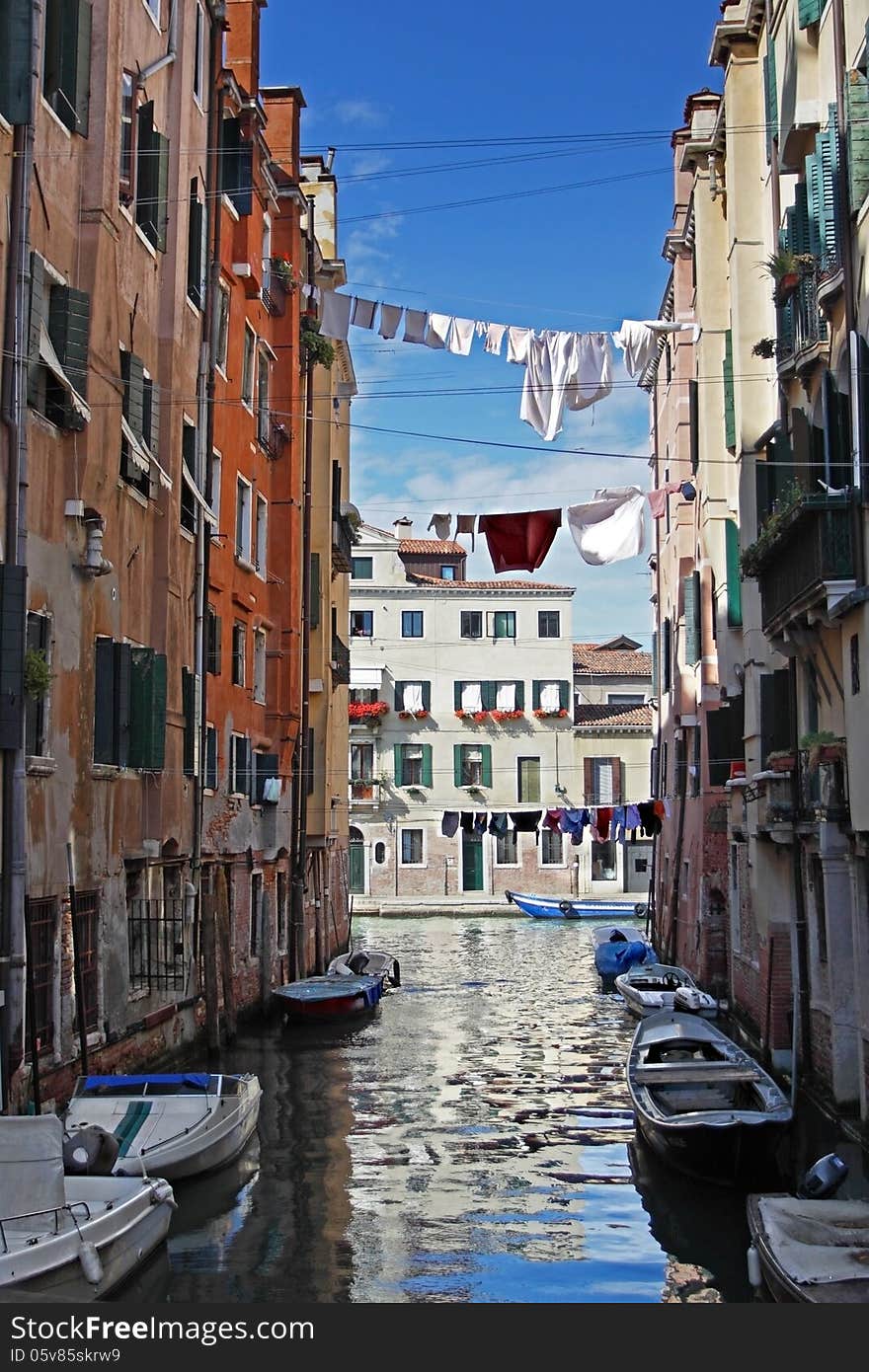 Venetian view with boats and drying clothes across the canal. Venetian view with boats and drying clothes across the canal