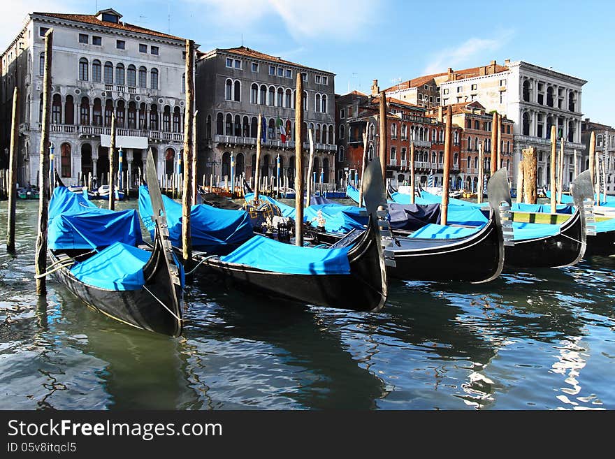 Venetian gondolas on canal with medieval buildings in background