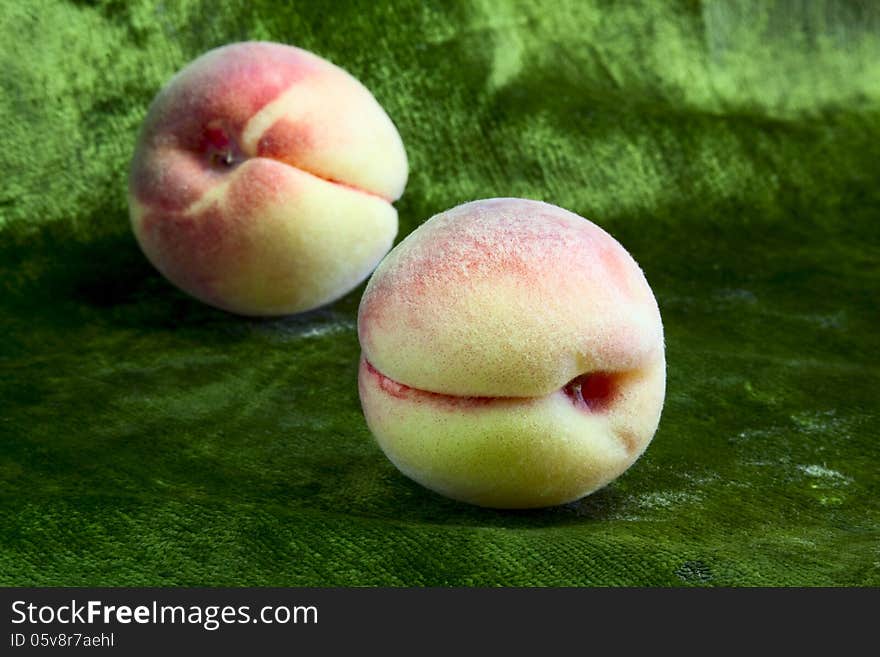 Gentle sweet peaches on green velvet background. Gentle sweet peaches on green velvet background