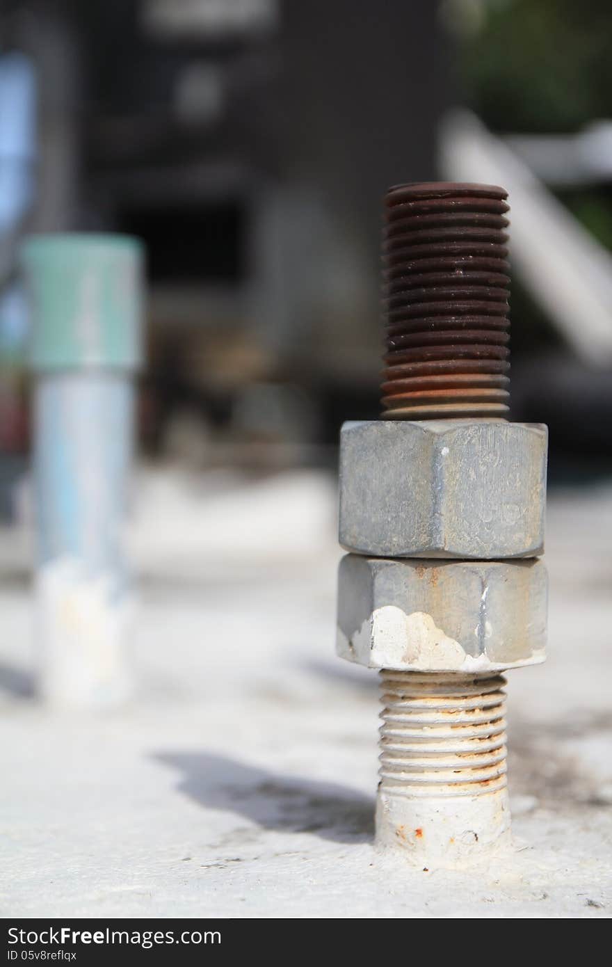 Close-up of rusted bolt with nuts, Grunge industrial construction.