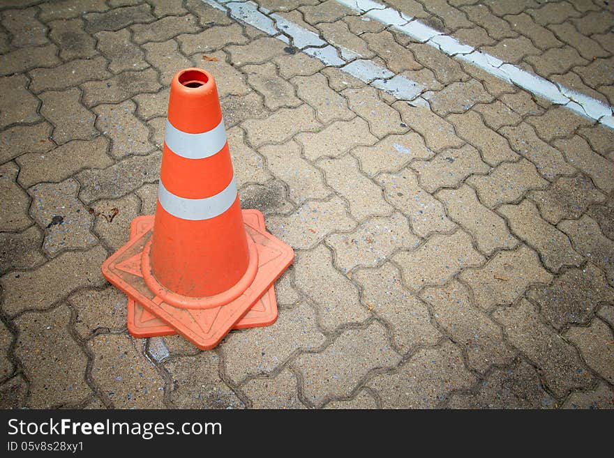 Red and white striped warning traffic cones stand on car park. Red and white striped warning traffic cones stand on car park