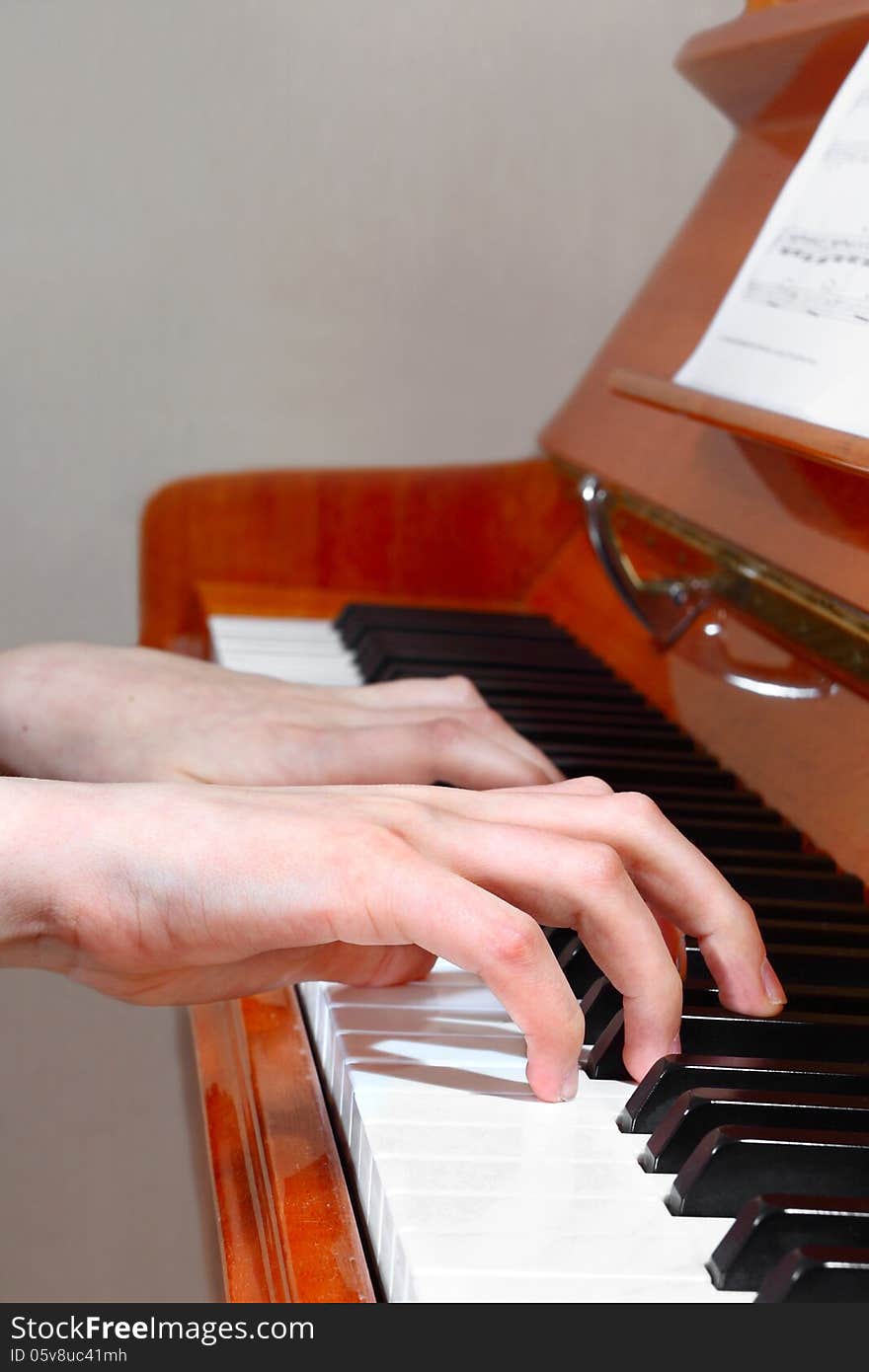 Closeup of hands playing the piano. Profile view. Closeup of hands playing the piano. Profile view