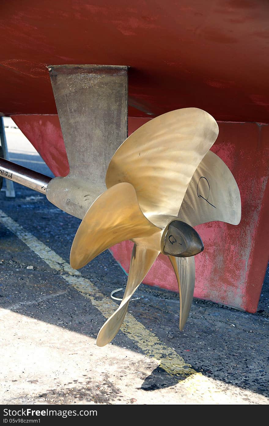A port side brass boat propeller on a life guard boat in dry dock
