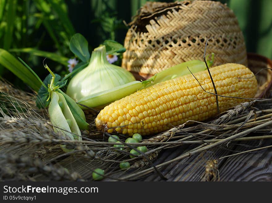 Ear of corn, peas, onion and straw hat.