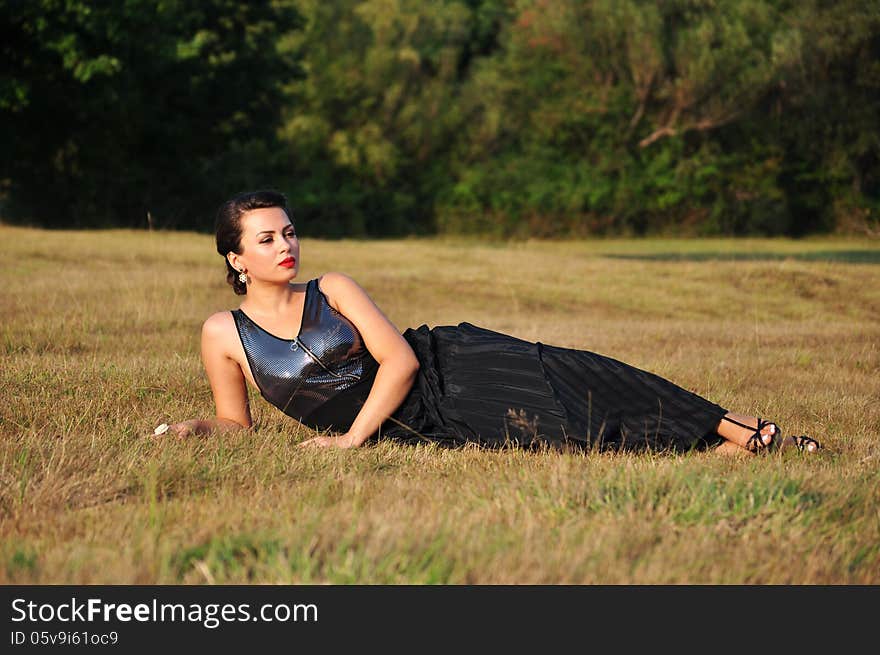 Woman lying in grass smiling happy.Beautiful girl in summer relaxing.