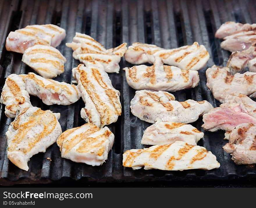 Fillet of chicken is fried on a grill. Fillet of chicken is fried on a grill