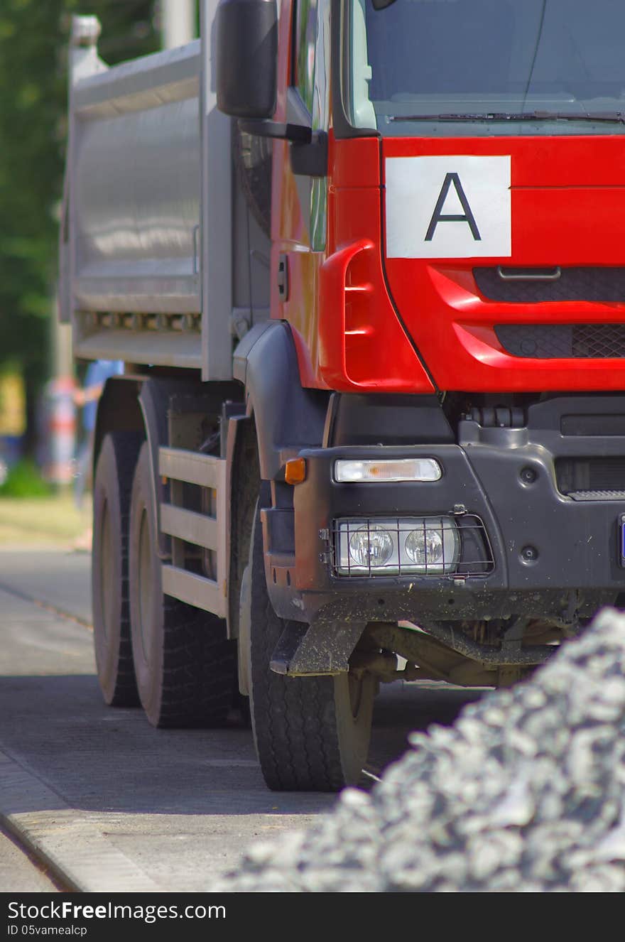 Red truck close up and a pile of gravel in foreground. Red truck close up and a pile of gravel in foreground