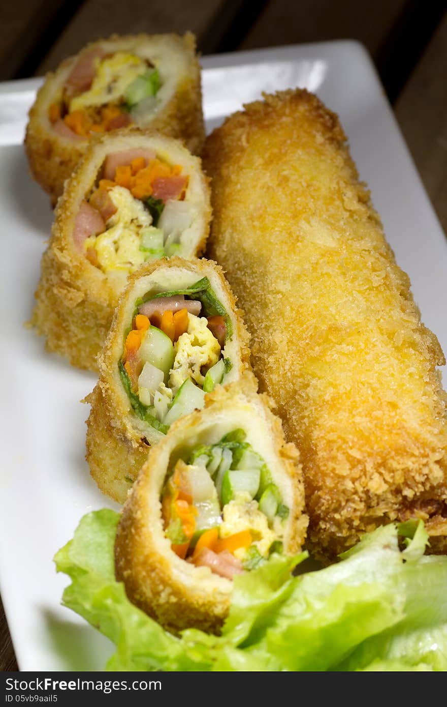 Deep Fried roll salad mix meal on white plate