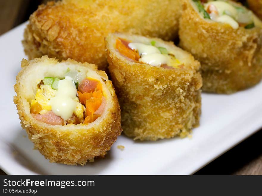 Deep Fried roll salad mix meal on white plate