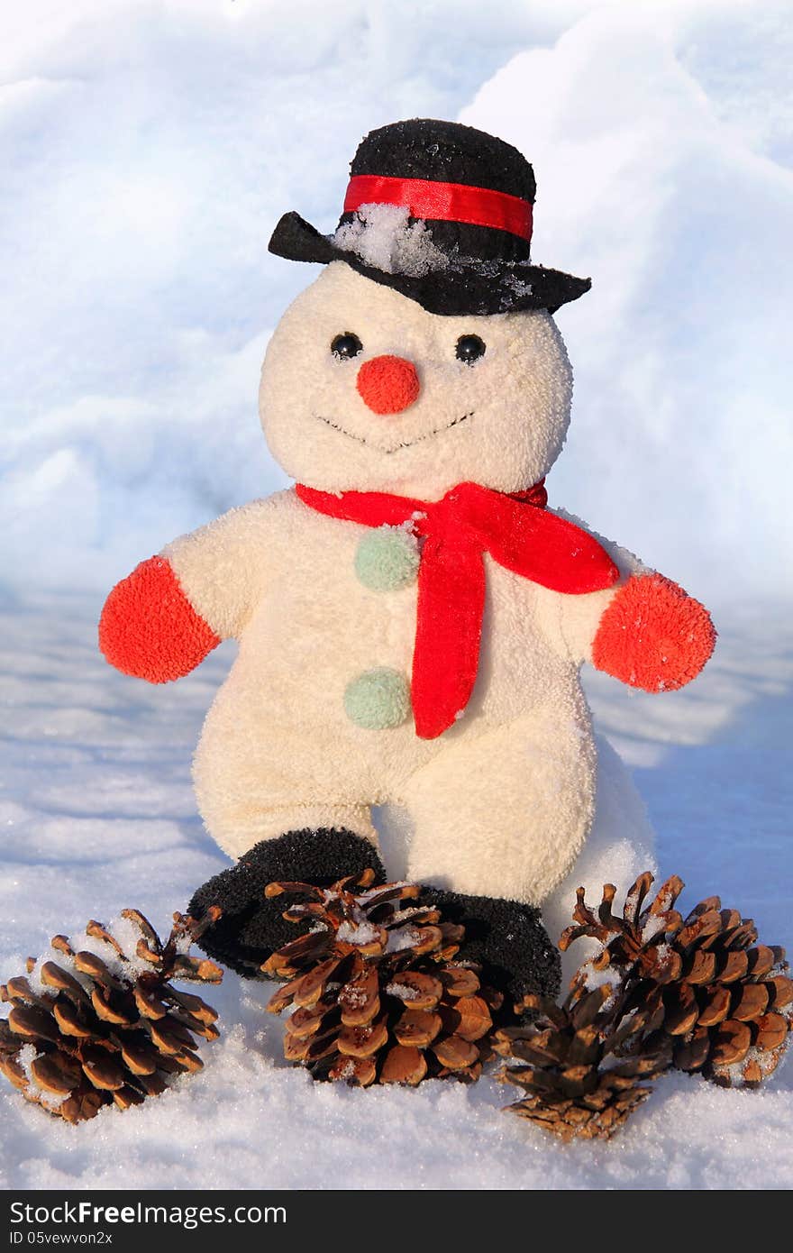 Toy snowman sitting in the snow with cones. Toy snowman sitting in the snow with cones