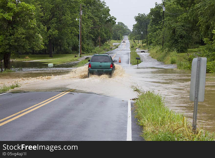 An SUV Driving On Flooded Road