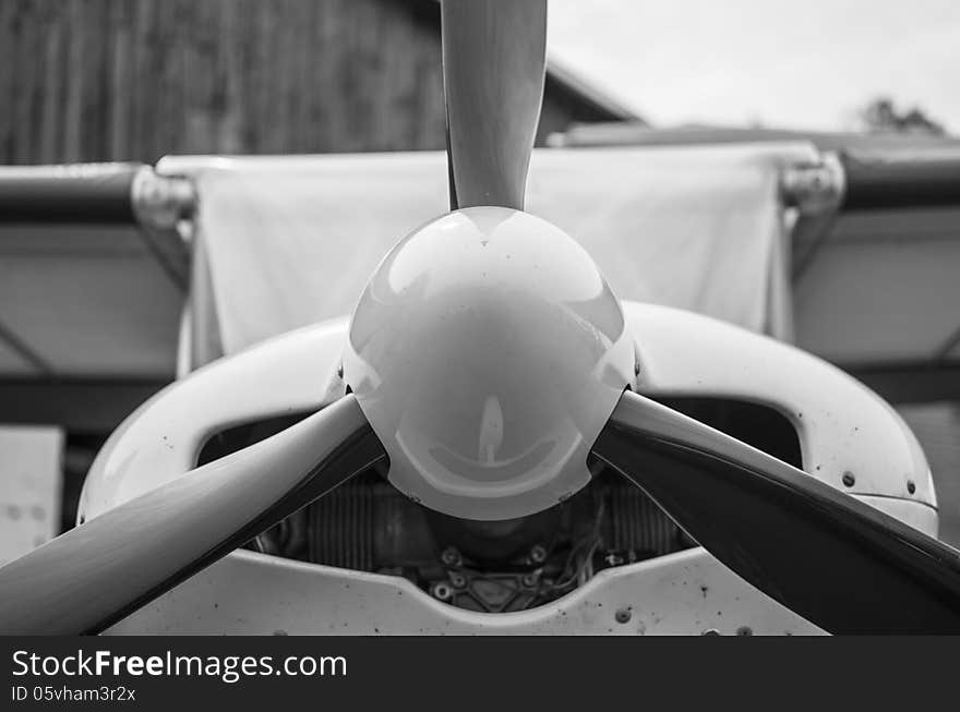 Front part of fuselage of a small light aircraft shot in black-and-white at a close distance. Front part of fuselage of a small light aircraft shot in black-and-white at a close distance