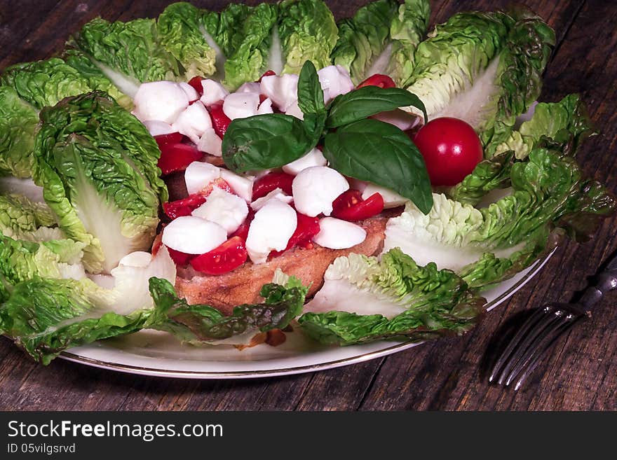 Close up of mozzarella tricolore salad with tomatoes and basil with drizzling. Close up of mozzarella tricolore salad with tomatoes and basil with drizzling