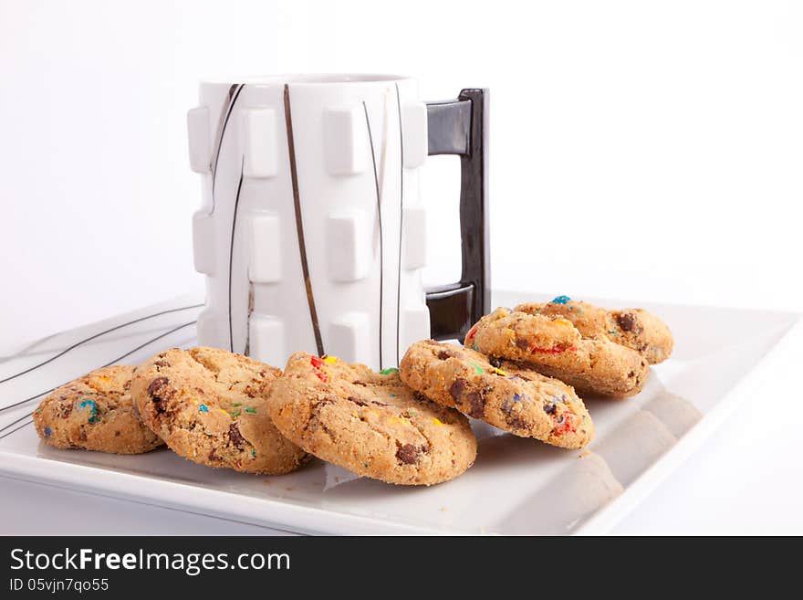 Cup of coffee with cookies staffed colored chocolate on white