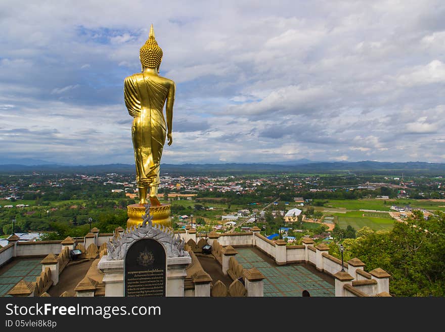 Golden buddha statue under cloudy sky in thailand temple