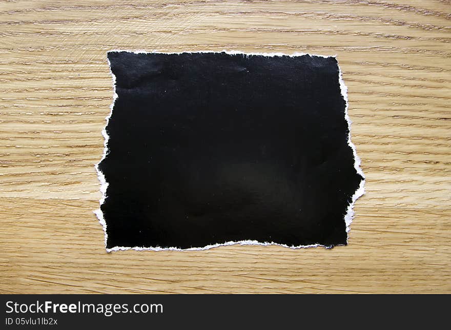 Piece of blank black paper isolated on wooden background. Piece of blank black paper isolated on wooden background