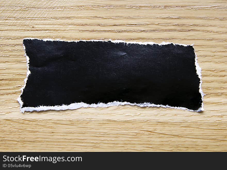 Piece of blank black paper isolated on wooden background. Piece of blank black paper isolated on wooden background