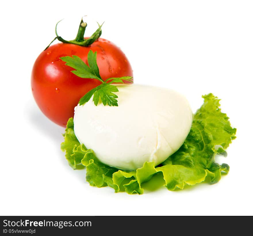 Fresh ball of mozzarella on lettuce leaf with tomato isolated over white