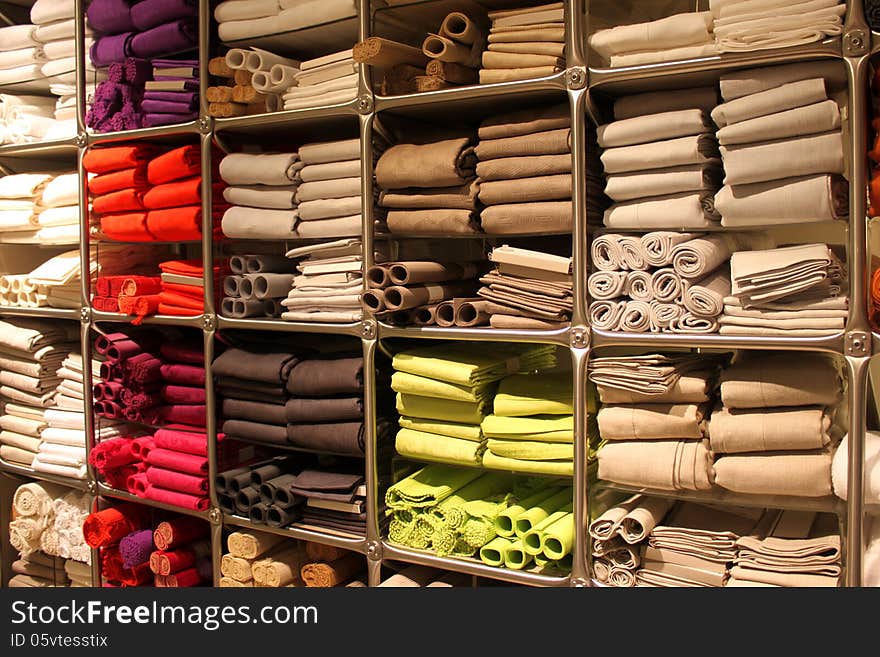 Colored kitchen towels stacked on shelves.Bright rolls of towels.