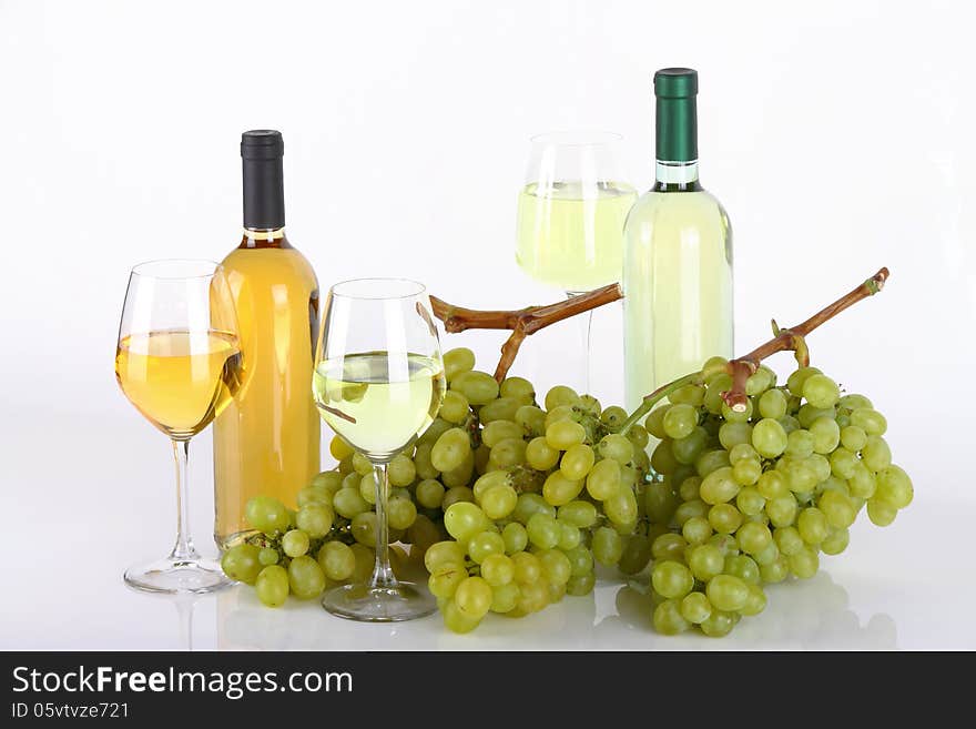 Glasses of white wine with white grapes on white background. Glasses of white wine with white grapes on white background