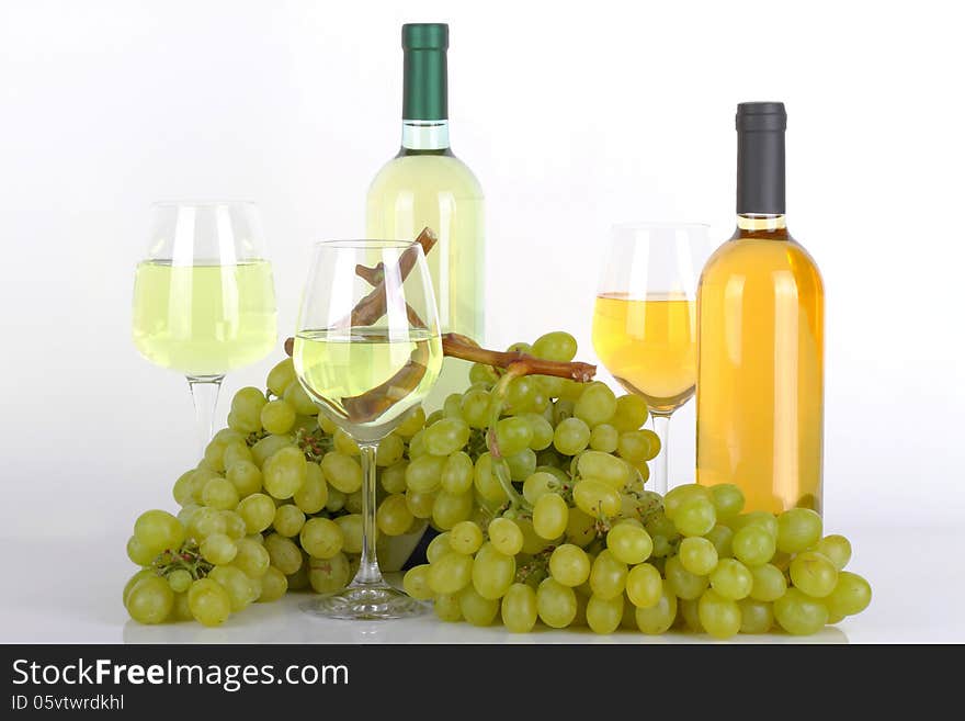 Glasses of white wine with white grapes on white background. Glasses of white wine with white grapes on white background