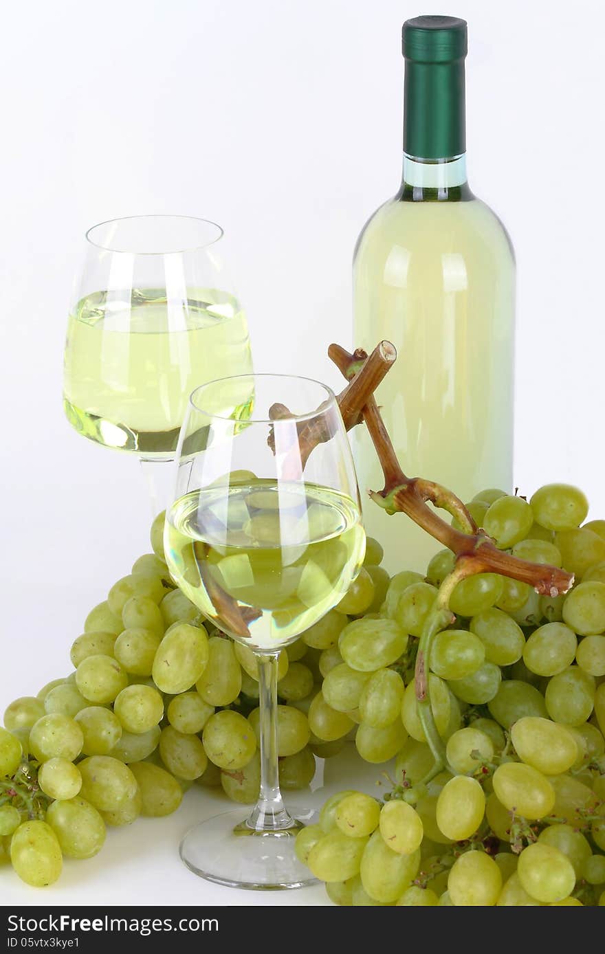 Glasses of white wine with white grapes on white background. Glasses of white wine with white grapes on white background