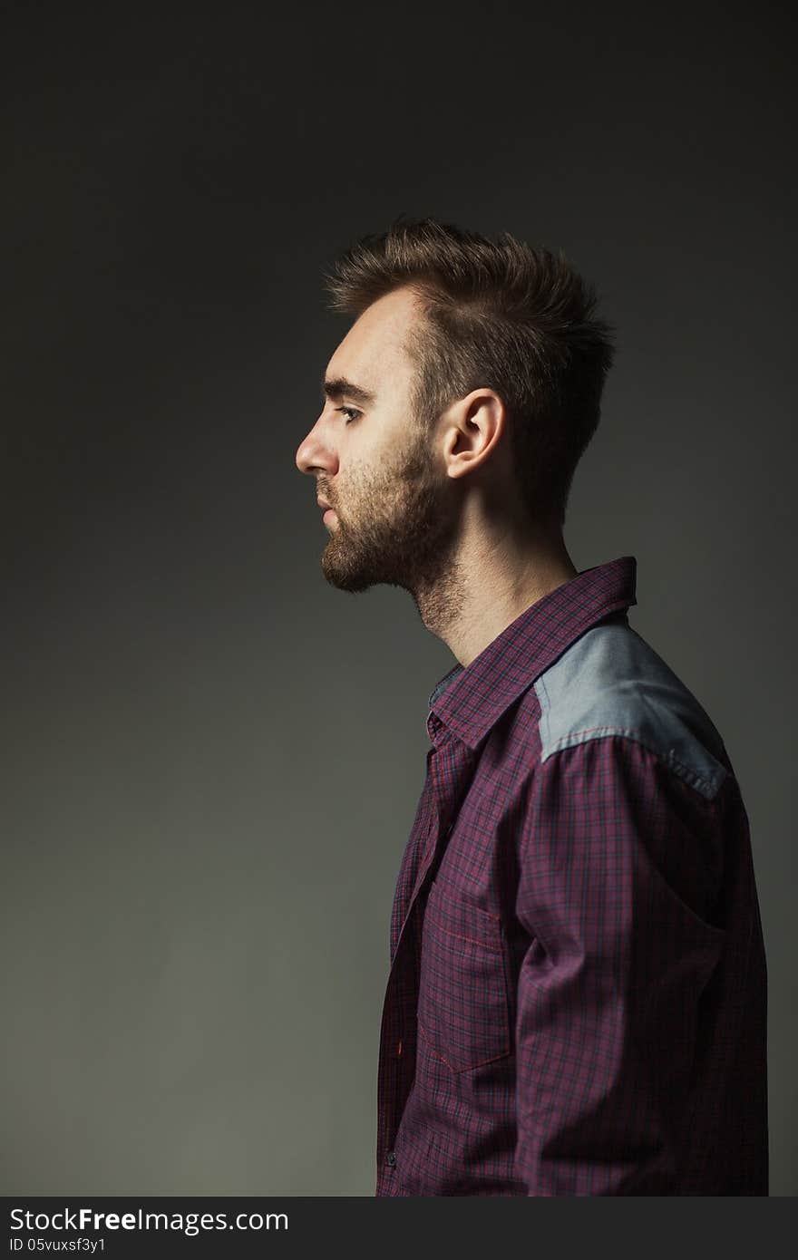 Young adult man on a dark background