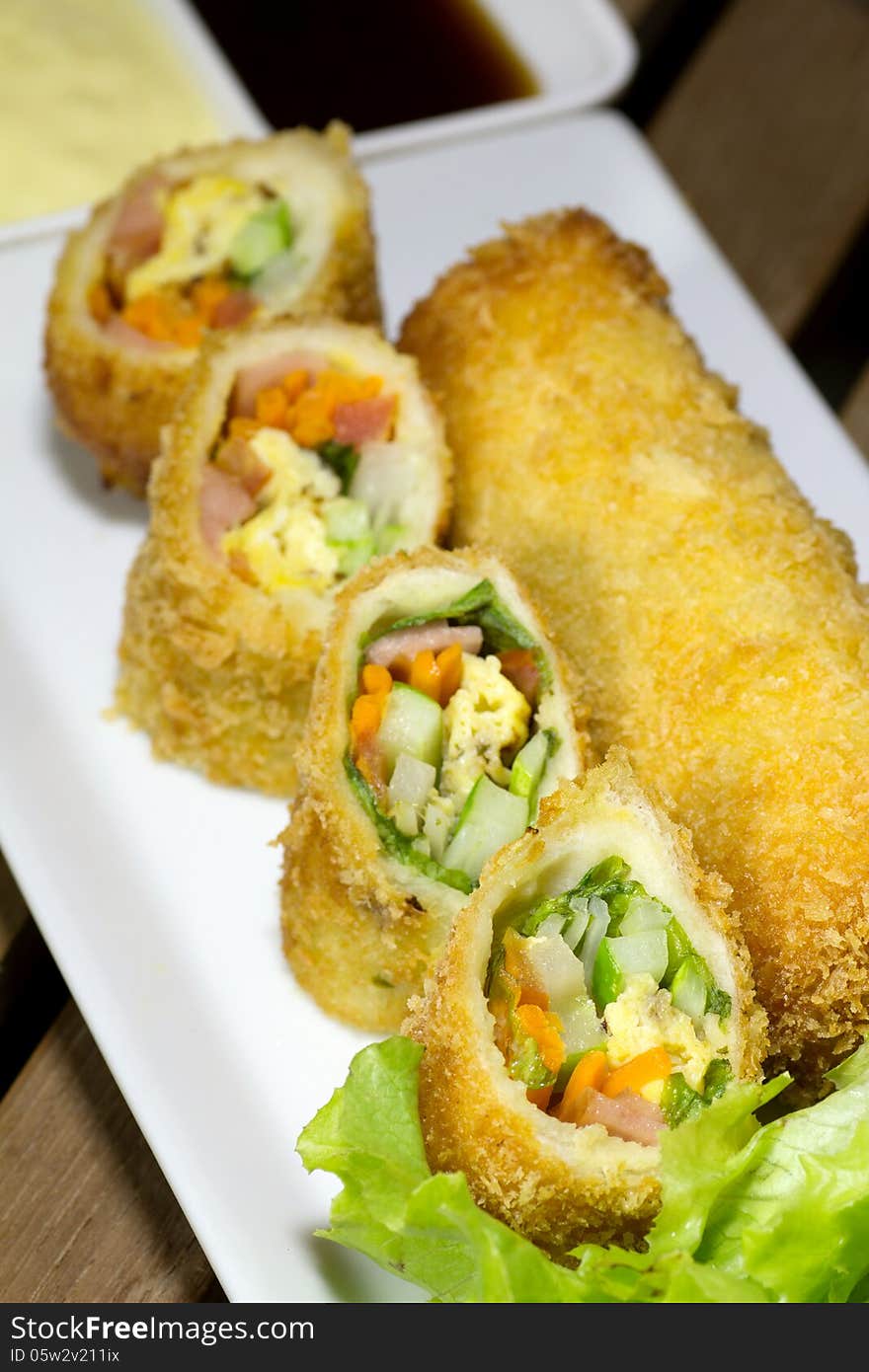 Deep Fried roll salad mix meal on white plate