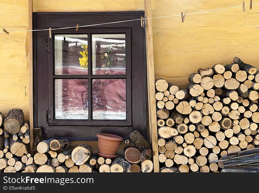 Wooden window of a traditional country cottage house with firewood logs. Wooden window of a traditional country cottage house with firewood logs.