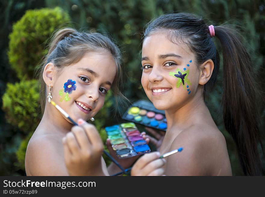 Playful young girls painted face. Playful young girls painted face