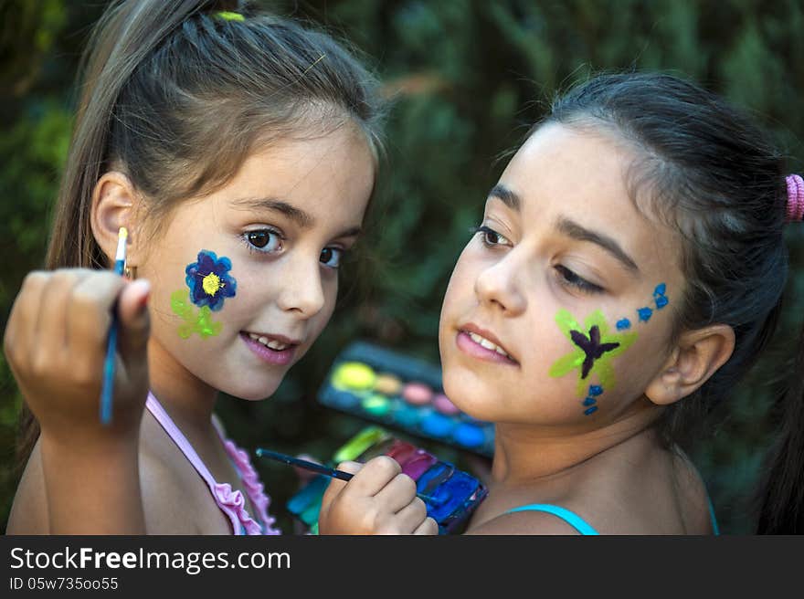 Playful children - girls painted face. Playful children - girls painted face