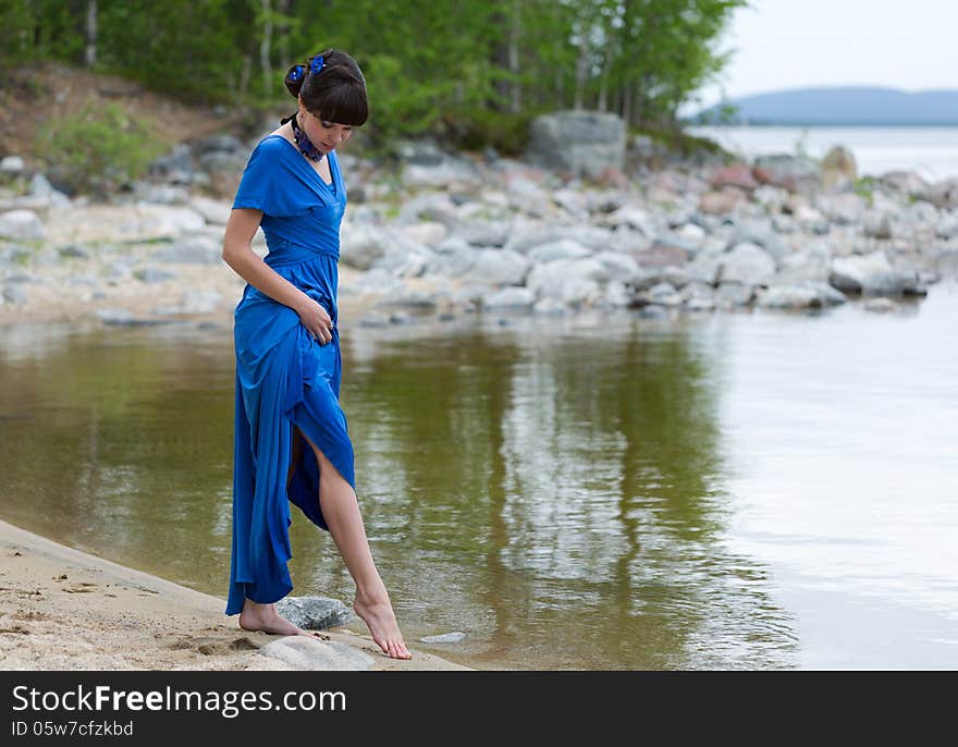 Girl in evening dress on a blue lake