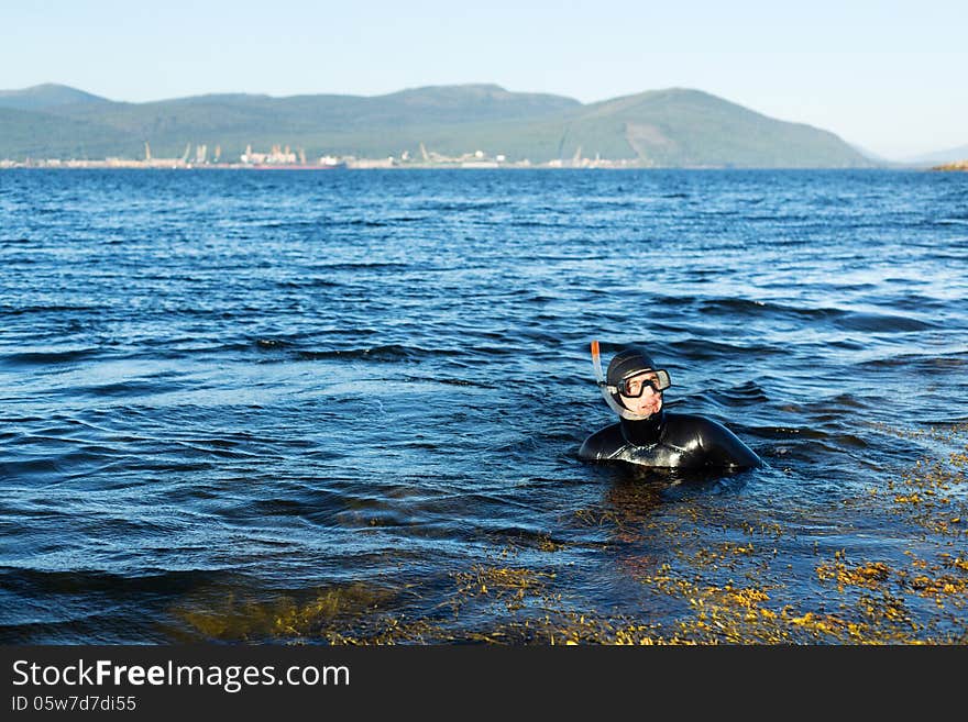 Underwater hunter in a wetsuit in water