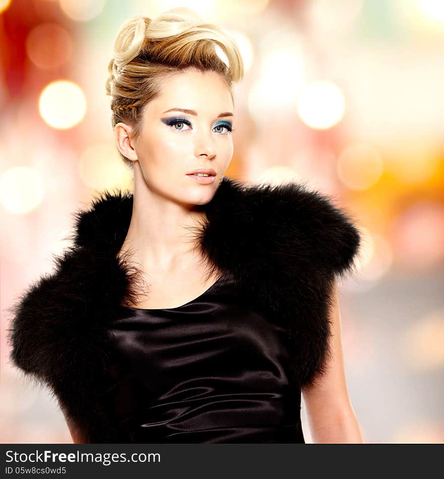 Portrait of the fashion beautiful blond woman with creative hairstyle posing at studio