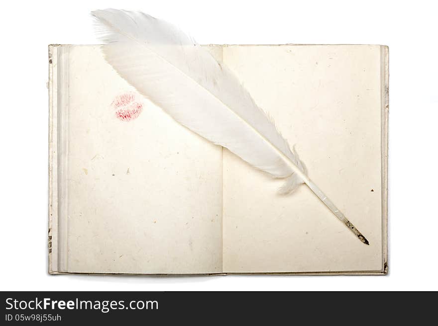 Open diary with japan paper lipstick kiss and feather pen isolated on white.