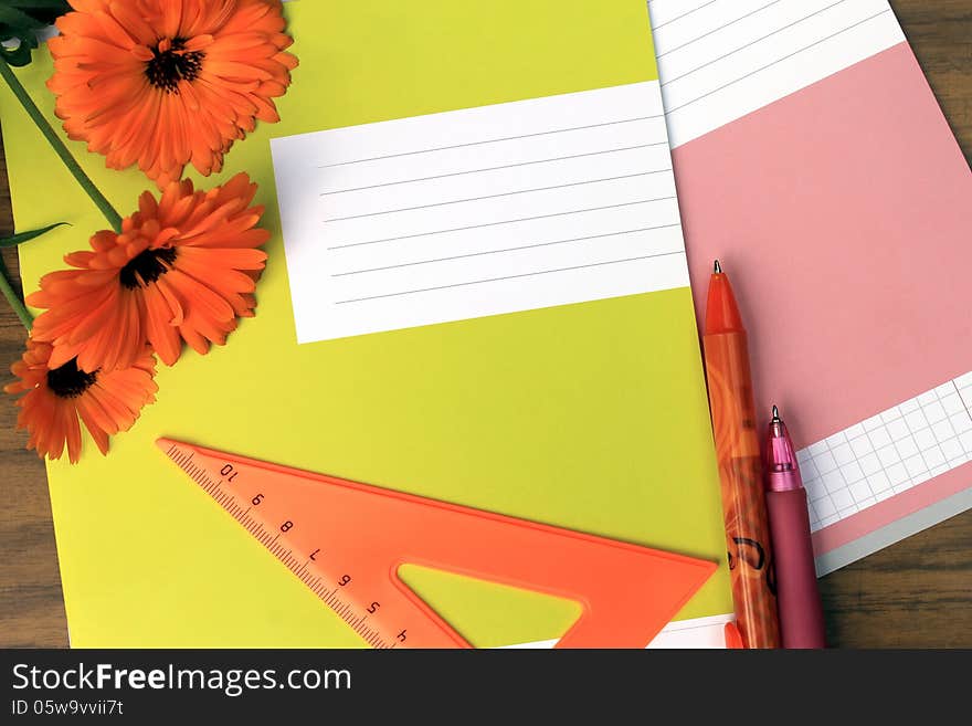 Notebooks, pens, ruler and flowers on the desk. Notebooks, pens, ruler and flowers on the desk.