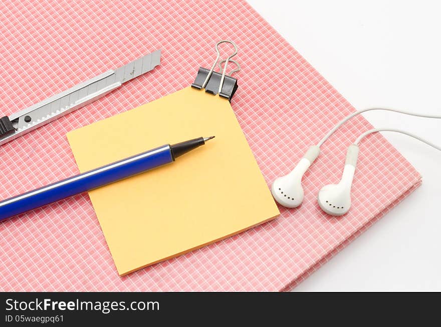 Red notebook with post it and bulldog clip blue pen cutter ear p