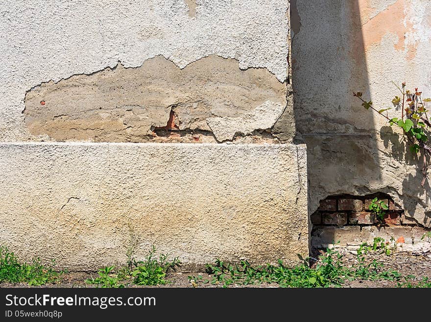 Split off the plaster on the shabby wall, visible brick. Split off the plaster on the shabby wall, visible brick