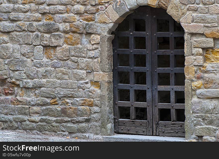 Old brown wooden gate in stone wall in the Carcassonne castle