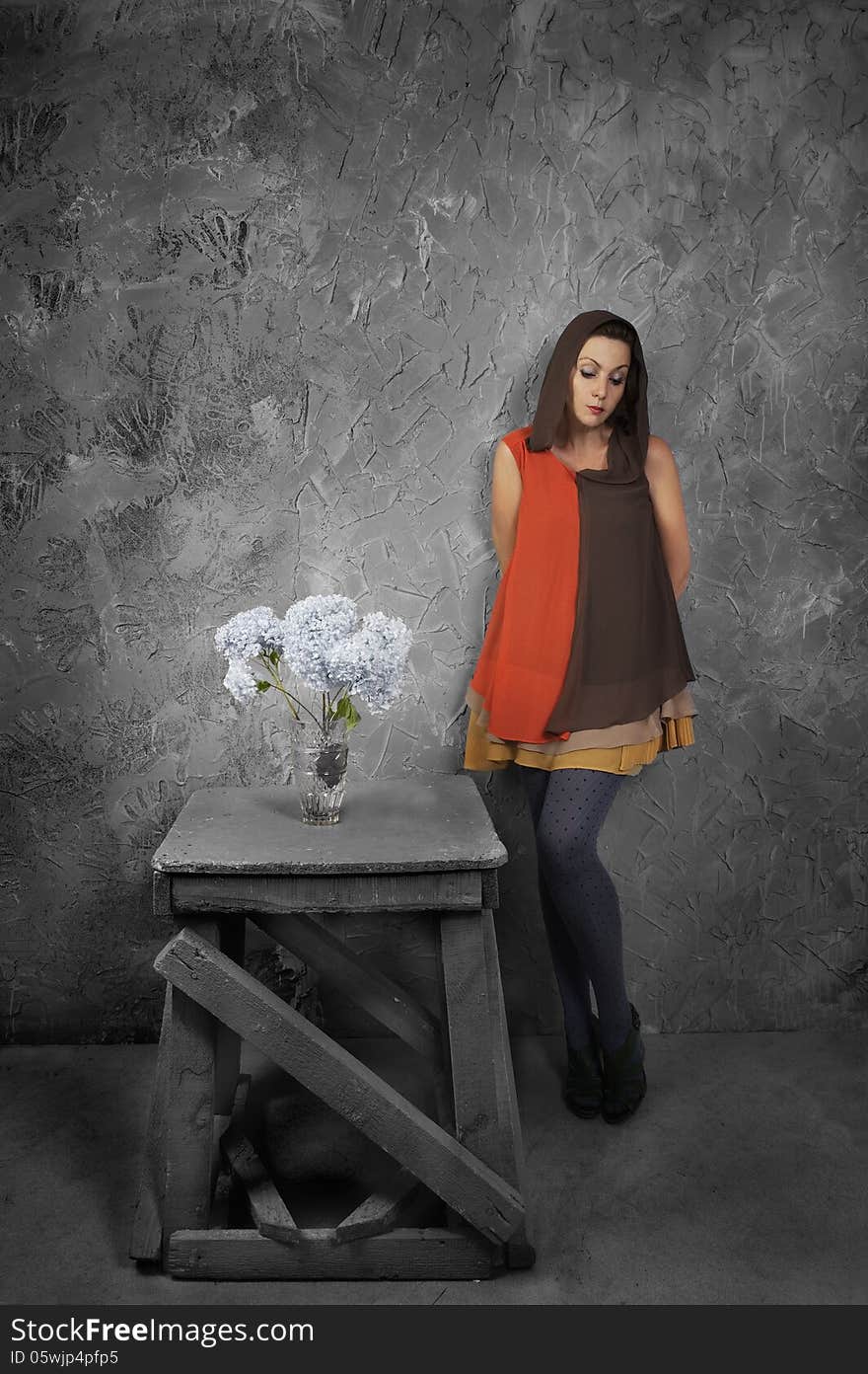 Studio portrait of a beautiful woman with flowers on grunge background