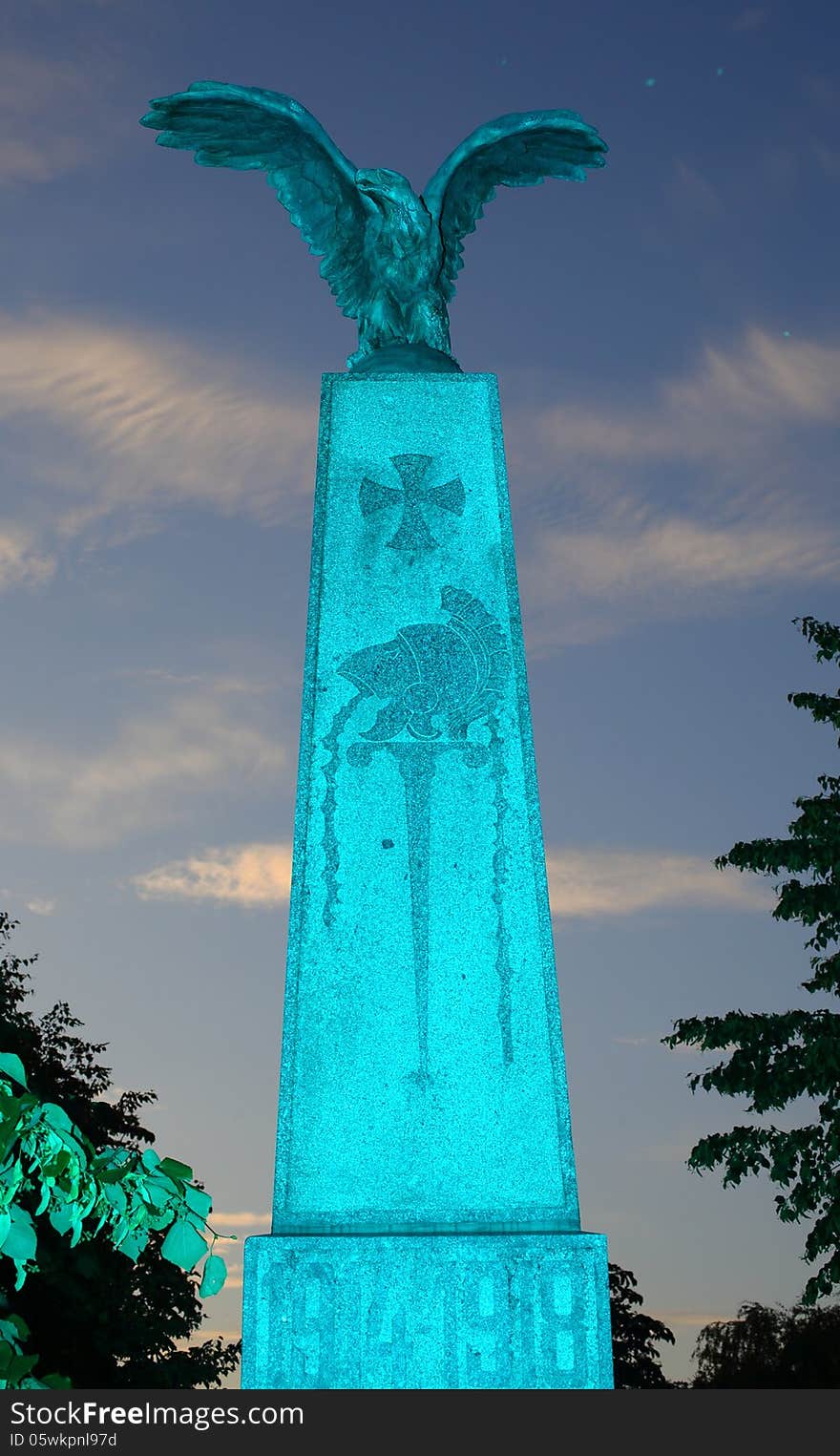 A monument consisting of a column of stone with an eagle of bronze on top of it, remainding of the deads of the world war 1914-1918, taken with cyan light. A monument consisting of a column of stone with an eagle of bronze on top of it, remainding of the deads of the world war 1914-1918, taken with cyan light