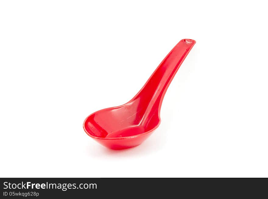 Red plastic spoon isolated on white